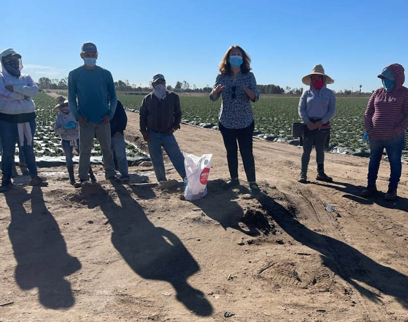 0422coronavirusvaccineequity Gloria Giraldo (center) of Latino Health Access discusses COVID-19 vaccine safety and effectiveness with agricultural workers at a farm in Irvine, California. (Photo courtesy of Latino Health Access)