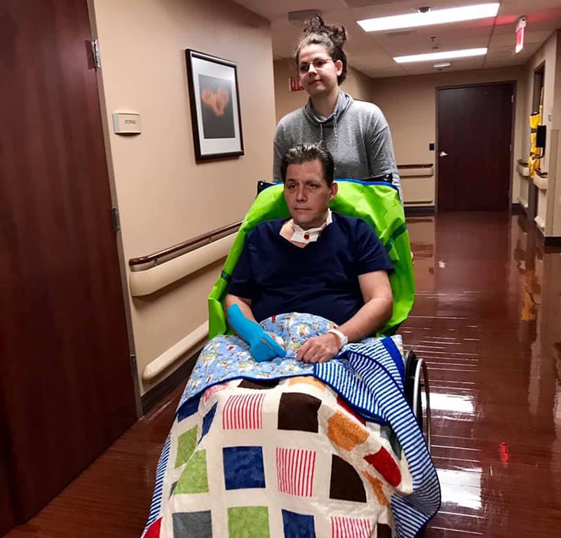 Mark Davis being pushed in a wheelchair by his daughter, Breanna Masters. (Photo courtesy of Mark Davis)