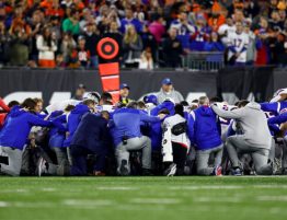 Buffalo Bills players and staff kneel after Damar Hamlin collapsed during an NFL football game against the Cincinnati Bengals on Jan. 2, 2023 in Cincinnati. (Kevin Sabitus/Getty Images)
