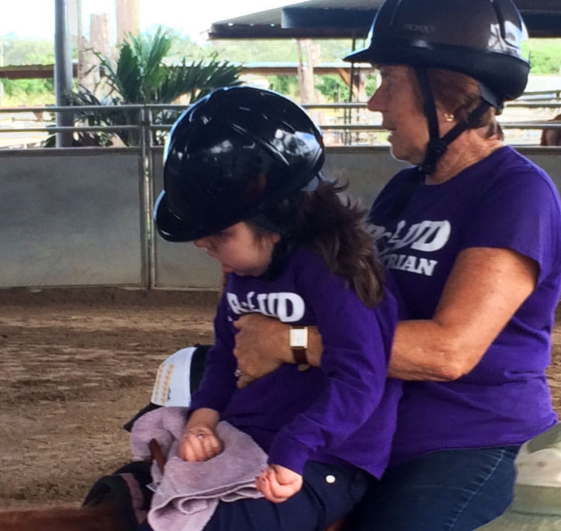 Abbie sharing a double saddle with her therapeutic riding instructor, Patti Silva.