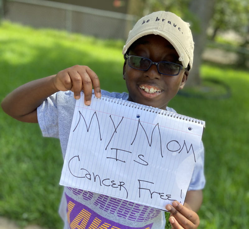 Brittany Clayborne's son, Micah, holding a sign that says his mom is cancer-free. (Photo courtesy of Brittany Clayborne)