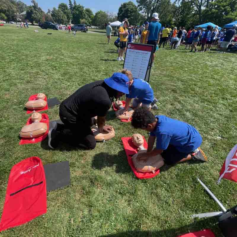 Alik Matthews shows students how to perform hands-only CPR during a Buffalo Bills training camp in Rochester, New York, in August. (Photo courtesy of Alik Matthews)
