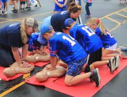 Volunteers help children learn CPR during the Buffalo Bills' training camp in Rochester, New York, in August 2023. (Photo courtesy of Alik Matthews)