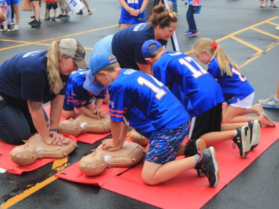 Volunteers help children learn CPR during the Buffalo Bills' training camp in Rochester, New York, in August 2023. (Photo courtesy of Alik Matthews)